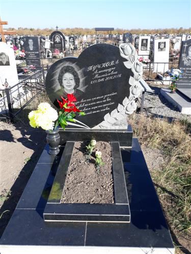 Надгробие в виде сердца из черного гранита с резными розами и цветником фото