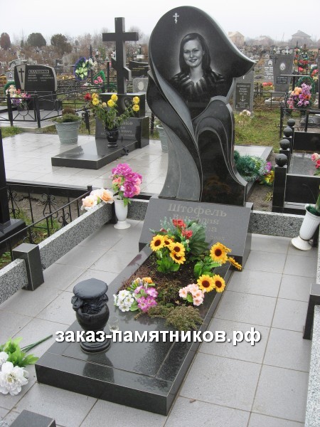 Памятник в виде тюльпана с черно-белым портретом фото