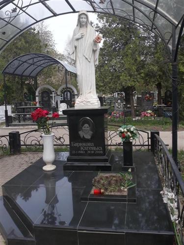 Монумент женщине со скульптурой девы с цветами в руках фото