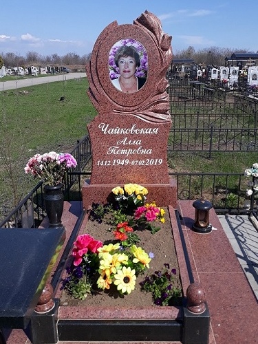Памятник жене из красного гранита с тюльпанами фото